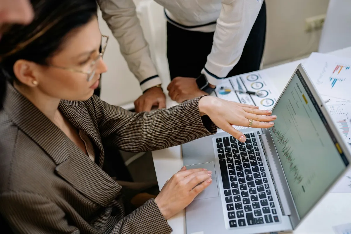 Ausbilder und Azubi besprechen Lernfortschritte am Laptop